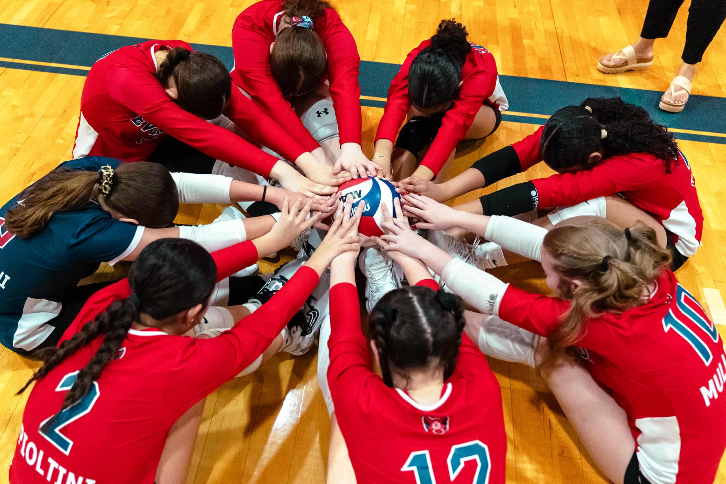 Evolution Volleyball athletes in a team huddle.