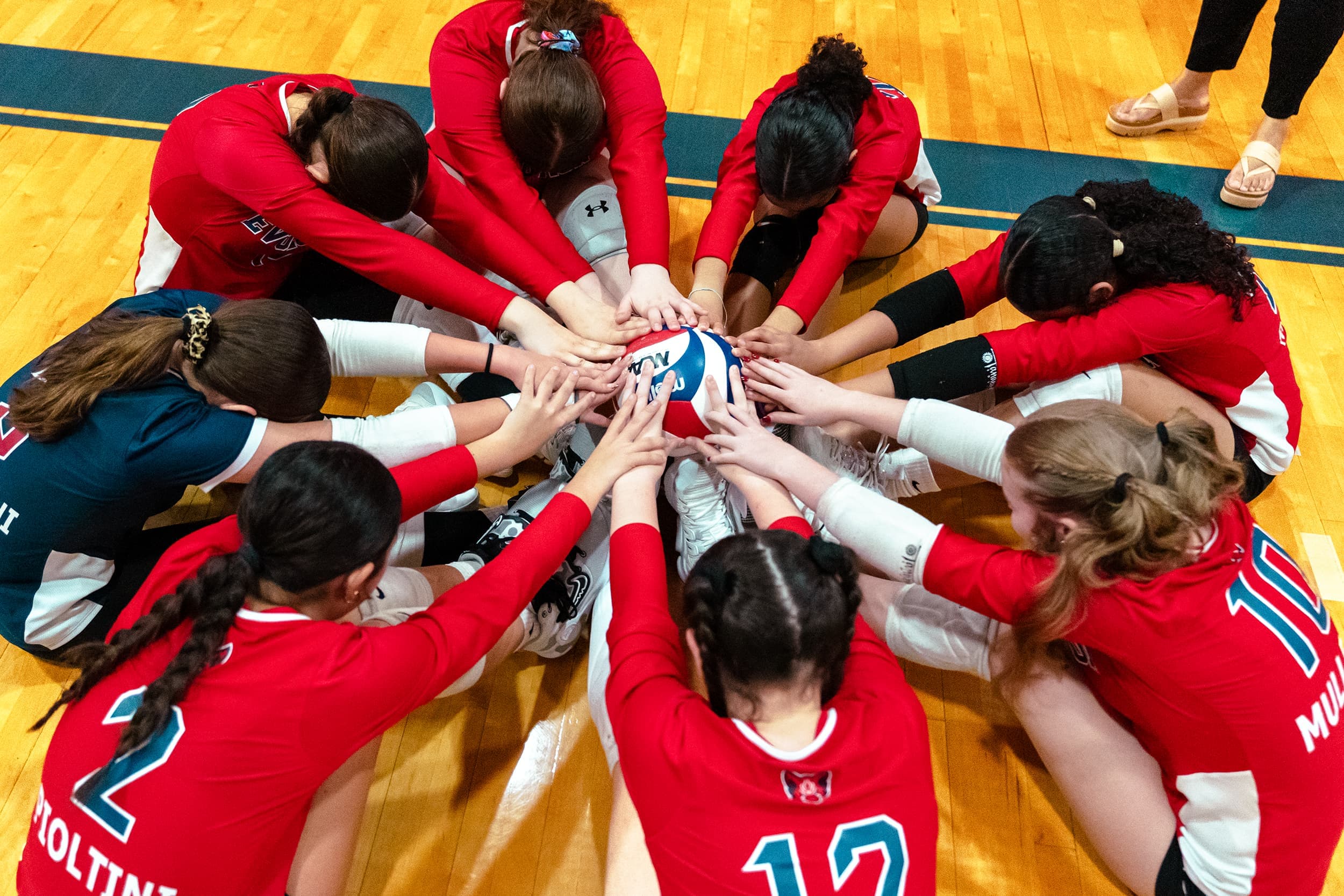Evolution Volleyball athletes gathered in a team huddle.